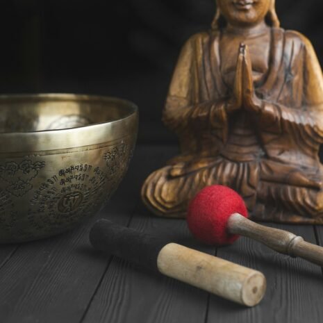 brass buddha figurine beside red and white stick